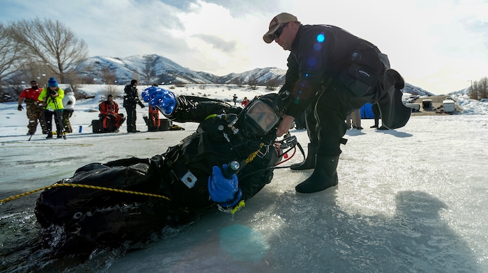 Leah Hogsten | The Salt Lake Tribune Utah Department of Public Safety's Dive Team member Colby Vanderbeek helps teammate Jeff Arbon out of the water. The Utah Department of Public Safety's Dive Team and the Riverside County Sheriff's Office joined forces for a day of ice diving at Deer Creek Reservoir, Feb. 20, 2019. Twenty members from Riverside County Sheriff's Department dove in icy waters alongside DPS' 10 man team in a joint team training day, Wednesday. Members of the Riverside County Sheriff's were working to become certified in ice diving under the team's lieutenant and dive master. Due to the equipment assets and the unique diver skill sets, dive teams are often called upon to provide assistance to aquatic homicide investigations and accidental drownings.