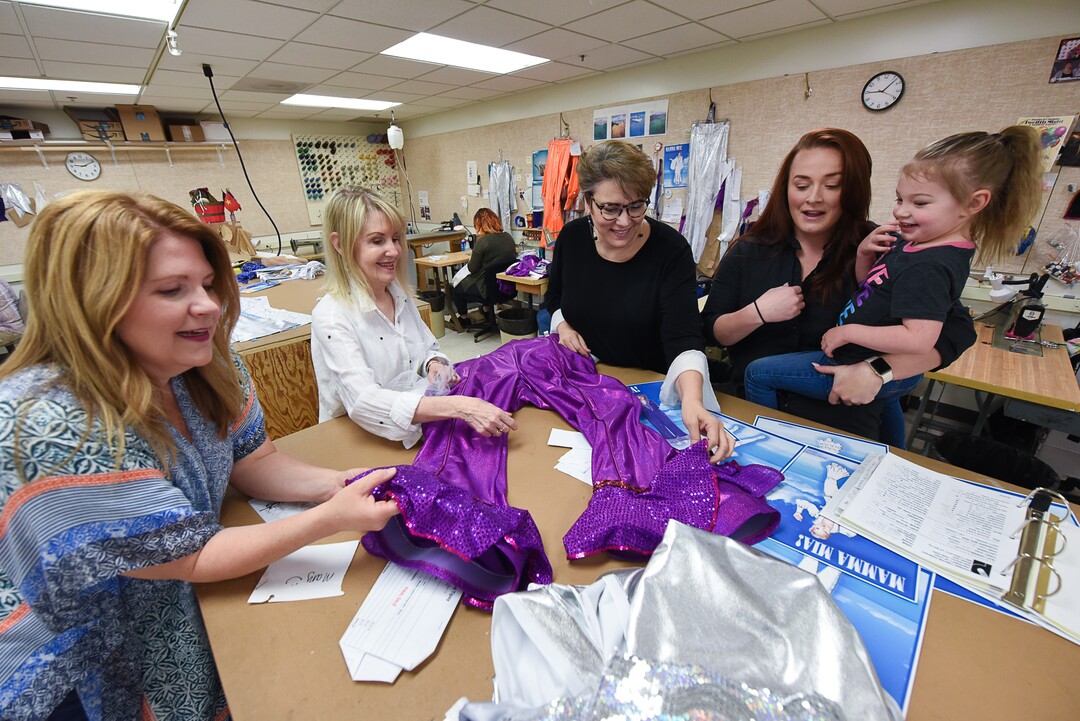 (Francisco Kjolseth  |  The Salt Lake Tribune)  Cast members of the musical "Mamma Mia!" geek out over one of the purple bell bottom pants scheduled to be worn by actor Mary Fanning Driggs, left, as she is joined by director/choreographer Patricia Wilcox, costume designer Brenda Van der Wiel and actor Megan Shenefelt holding her daughter Sovay, 3, in the costume shop at Pioneer Theatre.  