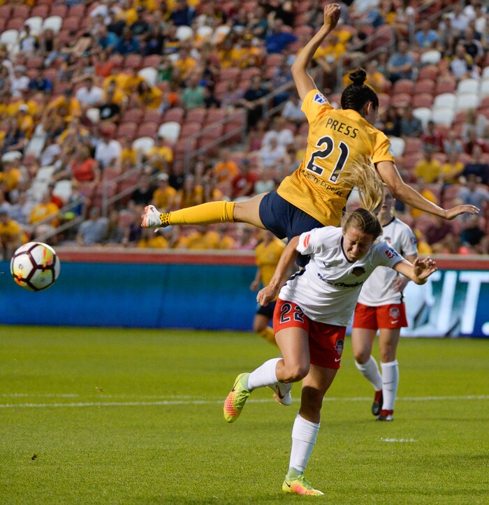 (Francisco Kjolseth  |  The Salt Lake Tribune)  Utah Royals FC hosts Washington Spirit, NWSL soccer at Rio Tinto Stadium in Sandy, Wed. Aug. 8, 2018. Utah Royals FC forward Christen Press (21) ends up in a precarious place over Washington Spirit forward Mallory Eubanks (22) following a header in the first half of the game. 