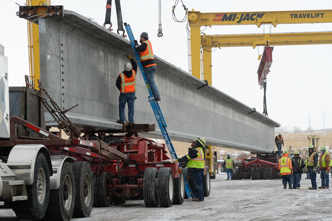 (Francisco Kjolseth  |  The Salt Lake Tribune)  UDOT gets ready to place some of the world's largest-ever bridge beams, and the largest in Utah state history with a span of 203 ft long and just over 8 ft tall, as crews load one on a truck following manufacturing at Forterra Structural Precast in Kearns on Tuesday, Dec. 11, 2018. A total of six beams will be installed in the technology corridor in Lehi later this week.