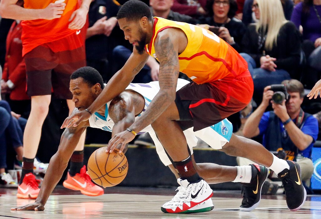Charlotte Hornets guard Treveon Graham, rear, and Utah Jazz forward Royce O'Neale battle for the ball in the first half during an NBA basketball game Friday, Feb. 9, 2018, in Salt Lake City. (AP Photo/Rick Bowmer)