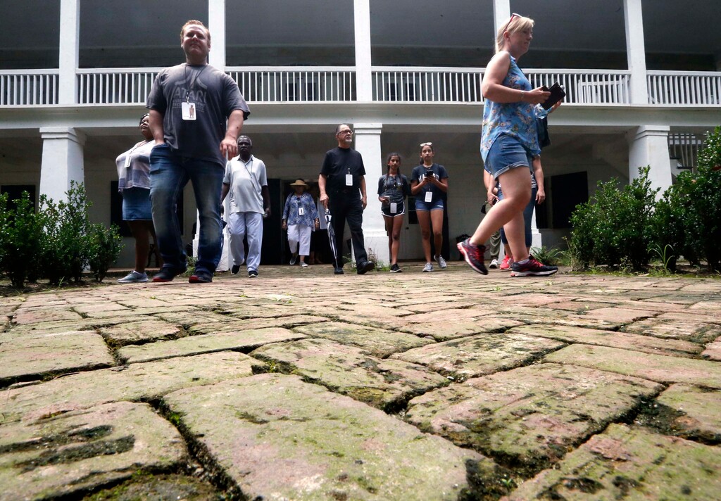 (Gerald Herbert | AP file photo) Visitors walk outside the main plantation house at the Whitney Plantation in Edgard, La., in 2017.