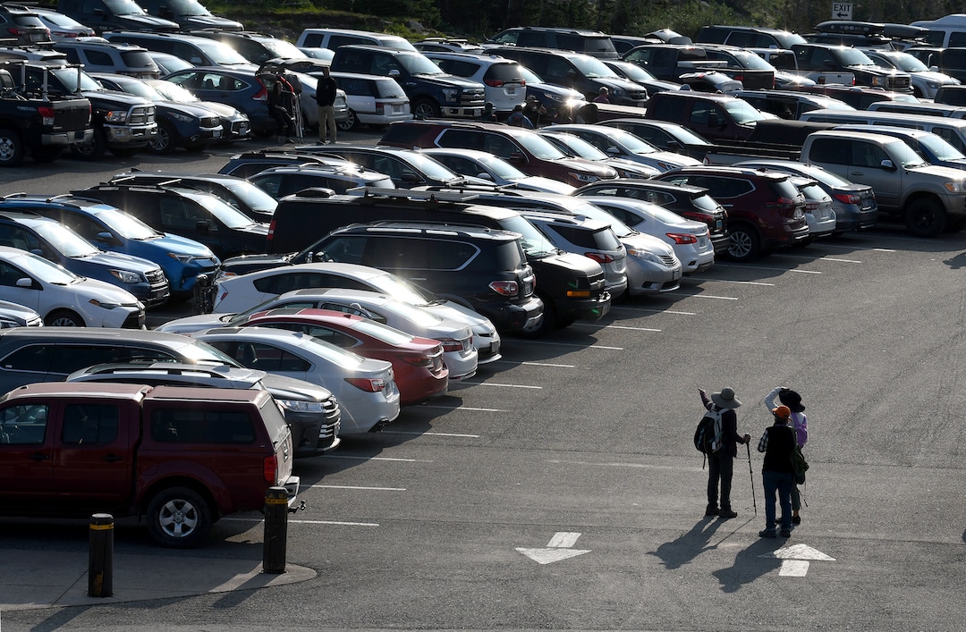 (Kurt Wilson  |  The Missoulian) Hikers stand in the full parking lot at Logan Pass in Glacier National Park, marking where they left their vehicle before hitting the trail. With the park's skyrocketing popularity, and most visitors wanting a trip to the top of the famous Going-to-the-Sun Road and the visitor's center there, park officials are seeking solutions to the crowds.