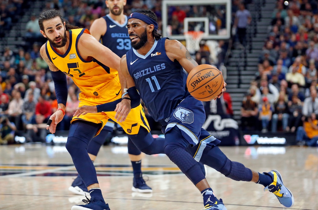 Memphis Grizzlies guard Mike Conley (11) drives to the basket as Utah Jazz guard Ricky Rubio, rear, defends in the first half of an NBA basketball game, Monday, Oct. 22, 2018, in Salt Lake City. (AP Photo/Rick Bowmer)