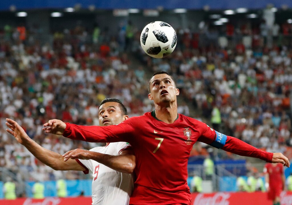 Portugal's Cristiano Ronaldo, right, and Iran's Omid Ebrahimi challenge for the ball during the group B match between Iran and Portugal at the 2018 soccer World Cup at the Mordovia Arena in Saransk, Russia, Monday, June 25, 2018. (AP Photo/Pavel Golovkin)