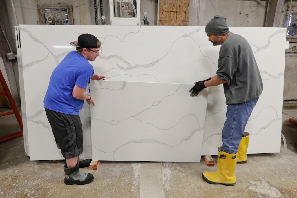 (Michael Conroy | The Associated Press) Workers move imported quartz slabs from China in an Indiana wareshouse. 