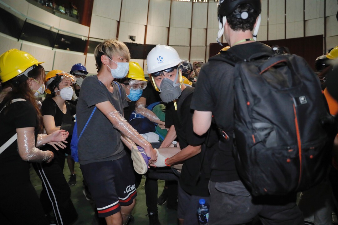 (Kin Cheung | AP Photo) Protesters try to drag out a fellow protester who wanted to stay and fight with the police from the meeting hall of the Legislative Council in Hong Kong, during the early hours of Tuesday, July 2, 2019. Protesters in Hong Kong took over the legislature's main building Friday night, tearing down portraits of legislative leaders and spray painting pro-democracy slogans on the walls of the main chamber.