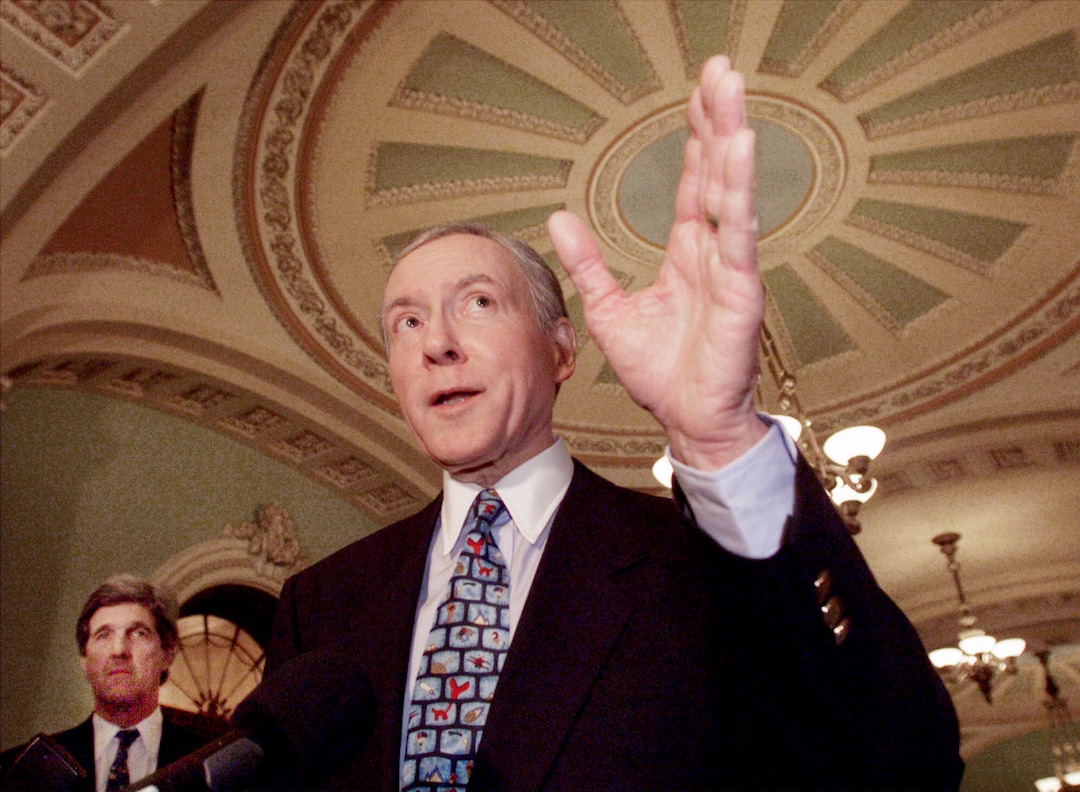 (Doug Mills | AP) Sen. Orrin Hatch talks to the media as Sen. John Kerry, D-Mass., left, watches during a break in the Senate impeachment trial of President Clinton, Saturday, Jan. 23, 1999, on Capitol Hill in Washington.