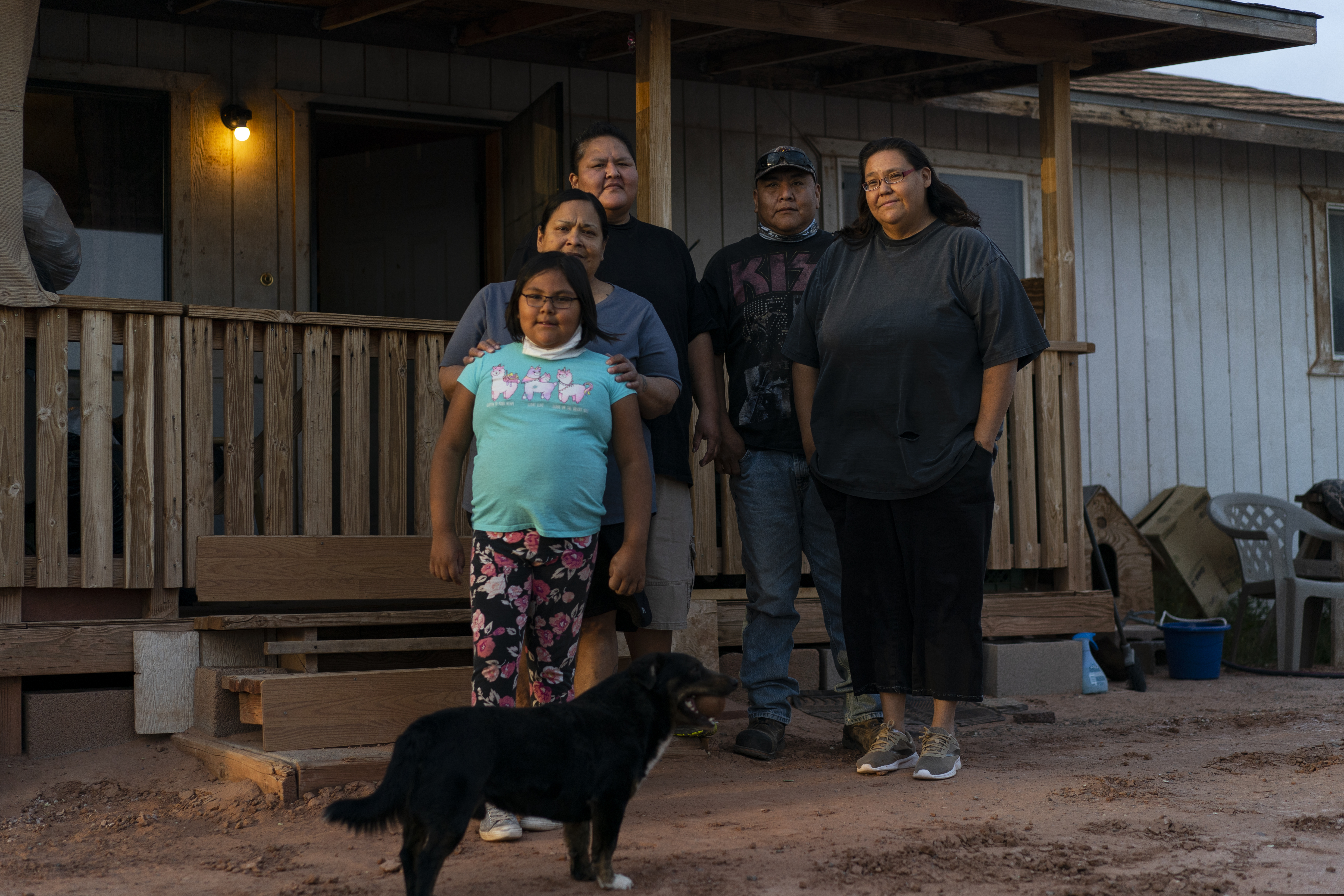 From left, Annabelle Dinehdeal, 8; Maria Cruz, Christina Dinehdeal, Eugene Dinehdeal, Angelina Dinehdeal, and their dog, Wally, pose for a photo on the Dinehdeal family compound in Tuba City, Ariz., on the Navajo reservation on April 20, 2020. The family has been devastated by COVID-19. (AP Photo/Carolyn Kaster)