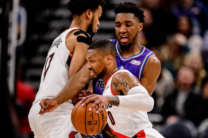 (Trent Nelson  |  The Salt Lake Tribune) Portland Trail Blazers guard Damian Lillard (0) drives, with Utah Jazz guard Donovan Mitchell (45) fighting through the pick as the Utah Jazz host the Portland Trail Blazers, NBA basketball in Salt Lake City on Thursday, Dec. 26, 2019.