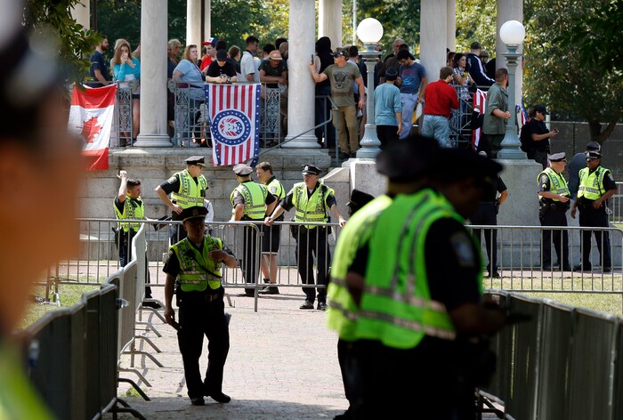 Police prepare to escort organizers from the bandstand on Boston Common after a "Free Speech" rally staged by conservative activists, Saturday, Aug. 19, 2017, in Boston.  One of the planned speakers of a conservative activist rally that appeared to end shortly after it began says the event "fell apart." Dozens of rallygoers gathered Saturday on Boston Common, but then left less than an hour after the event was getting underway. Thousands of counterprotesters had also gathered. (AP Photo/Michael Dwyer)