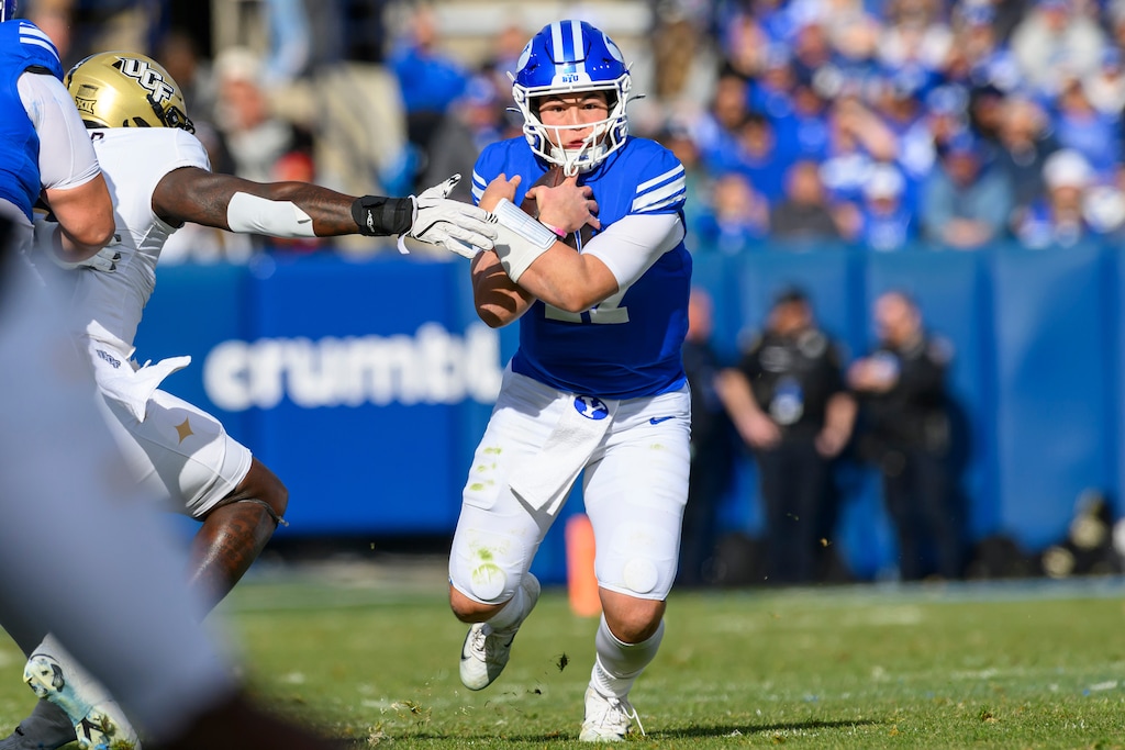 BYU quarterback Bear Bachmeier, center, runs the ball for a first down during the first half an NCAA college football game against Central Florida, Saturday, Nov. 29, 2025, in Provo, Utah. (AP Photo/Tyler Tate)