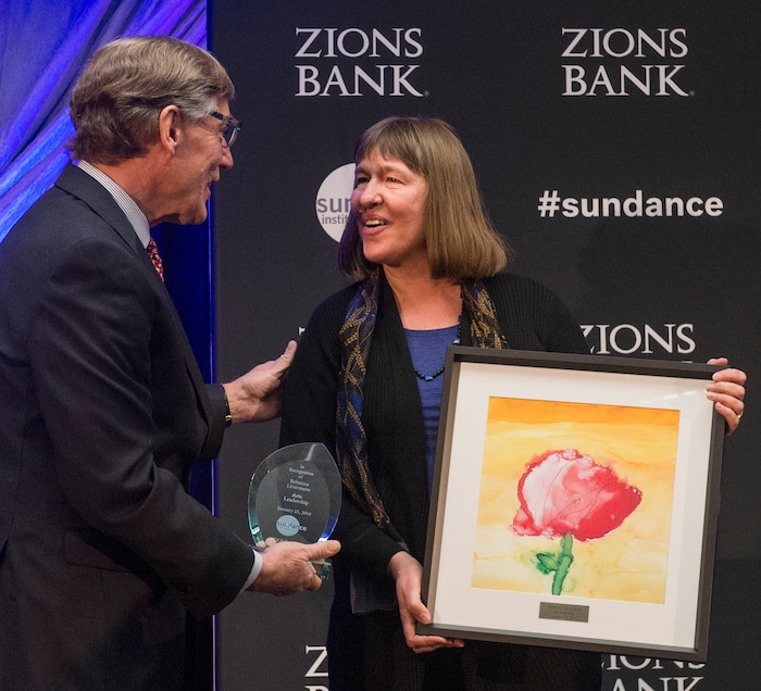 (Rick Egan  |  The Salt Lake Tribune)     Artist Rebecca Livermore receives a leadership award from Scott Anderson, president and CEO of Zions Bank, at the 2018 Sundance Film Festival Utah Women’s Leadership Celebration in Park City on Thursday, Jan. 25, 2018.