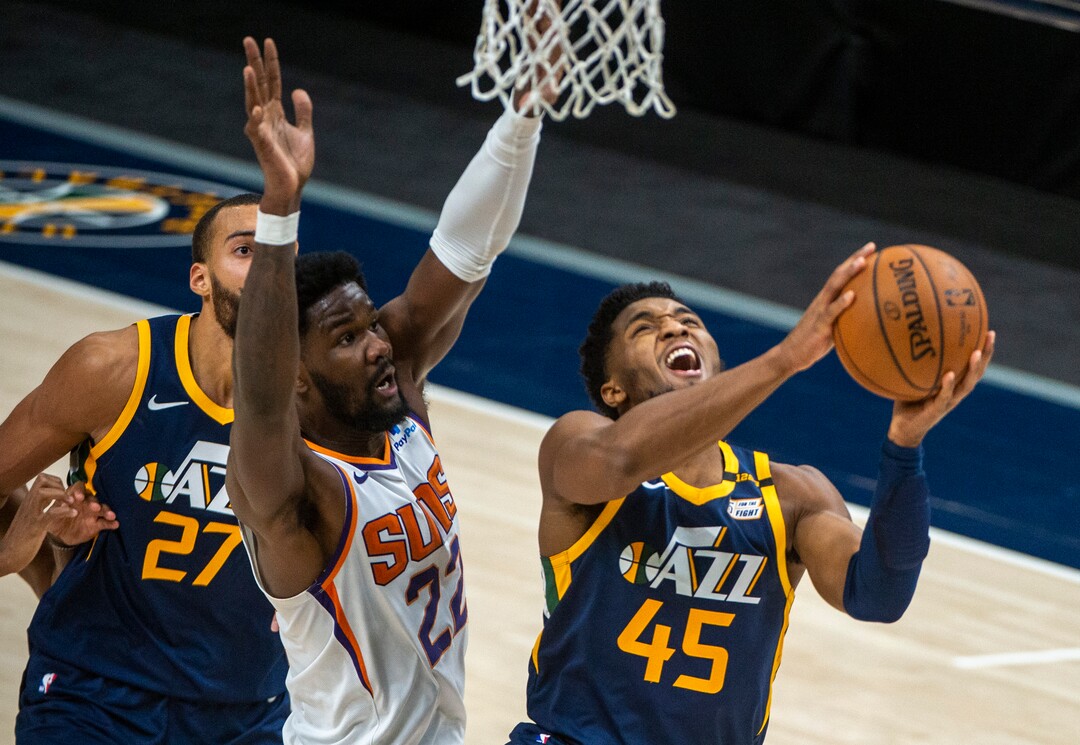 (Rick Egan | The Salt Lake Tribune) Utah Jazz guard Donovan Mitchell (45) takes the ball to the basket in the final minutes of the game as Phoenix Suns center Deandre Ayton (22) defends, in NBA action between the Utah Jazz and the Phoenix Suns, on Thursday, Dec. 31, 2020.
