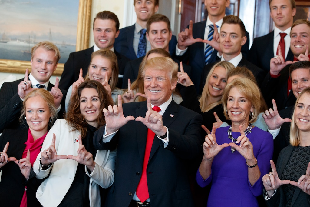 President Donald Trump poses for photos with the University of Utah ski team during an event with NCAA championship teams at the White House, Friday, Nov. 17, 2017, in Washington. Education Secretary Betsy DeVos is to the right of the President.  (AP Photo/Evan Vucci)