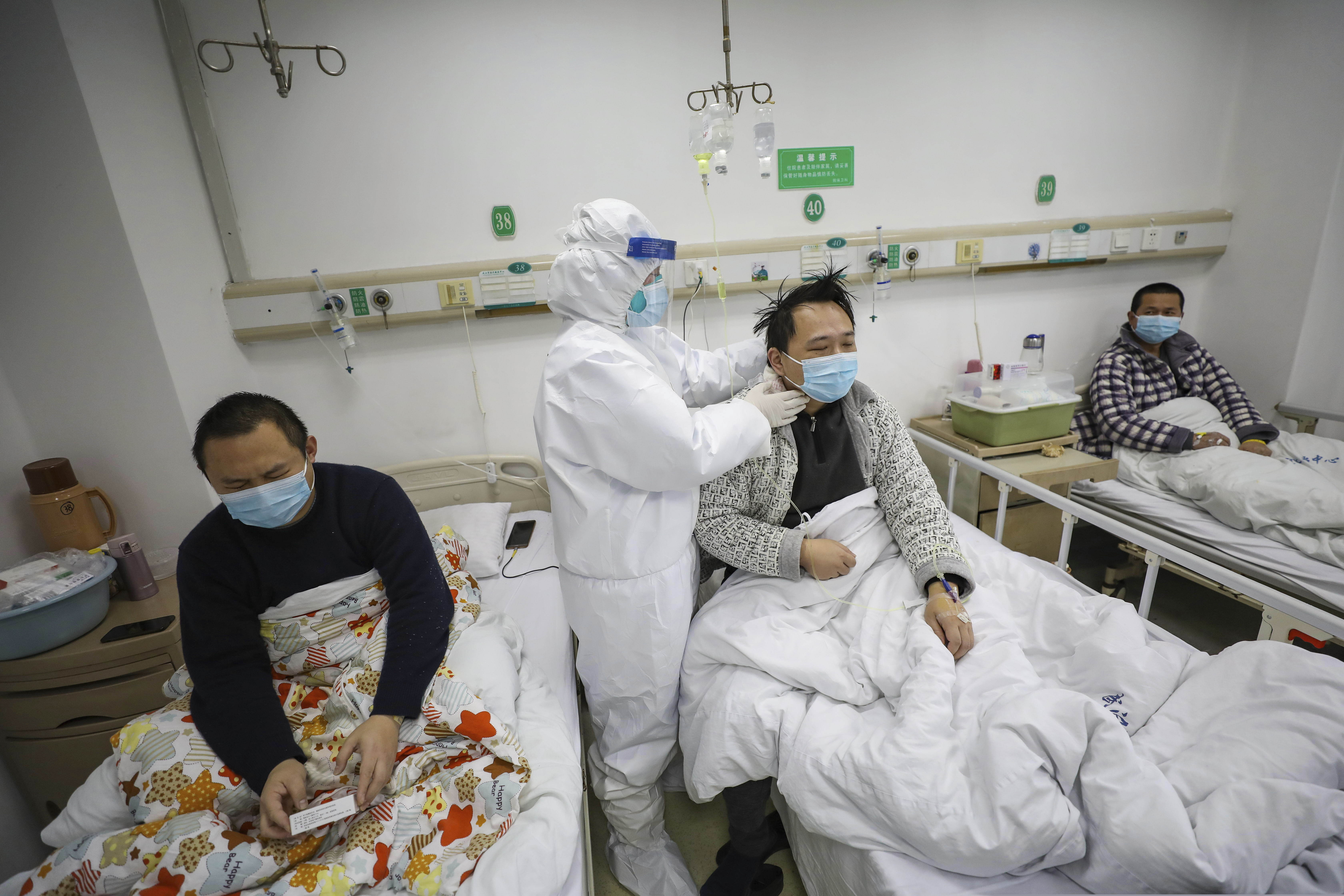 (Chinatopix via AP) A doctor checks the conditions of a patient in Jinyintan Hospital, designated for critical COVID-19 patients, in Wuhan in central China's Hubei province Thursday, Feb. 13, 2020. China on Thursday reported 254 new deaths and a spike in virus cases of 15,152, after the hardest-hit province of Hubei applied a new classification system that broadens the scope of diagnoses for the outbreak, which has spread to more than 20 countries.
