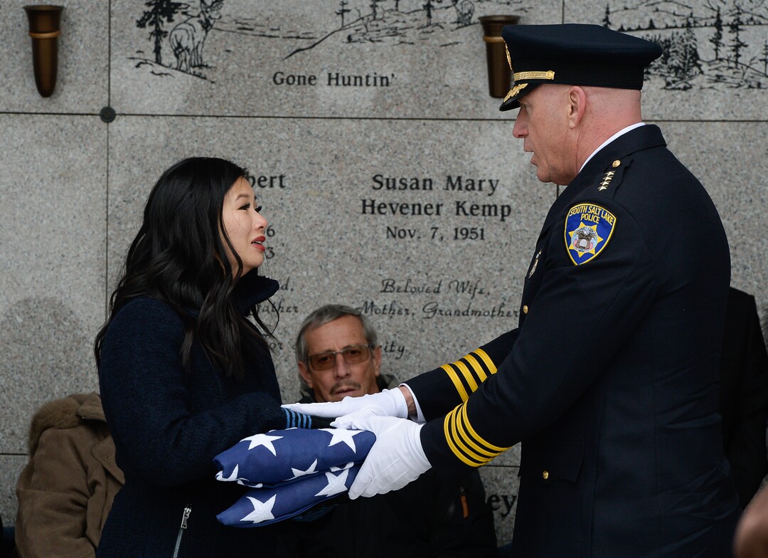 (Francisco Kjolseth  |  The Salt Lake Tribune)  Elizabeth Romrell, wife of police officer David Romrell is presented his folded flag by South Salt Lake Police Chief Jack Caruth  during funeral services at Larkin Sunset Gardens Cemetery in Sandy, Wed. Dec. 5, 2018.