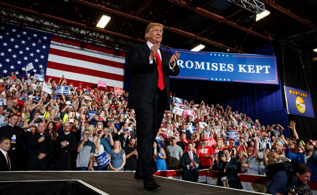 (AP Photo/Carolyn Kaster, File) In this July 5, 2018, file photo, three of the four Roman Catholic priests are visible in the front row at lower left as President Donald Trump arrives to speak during a rally at the Four Seasons Arena at Montana ExpoPark in Great Falls, Mont.