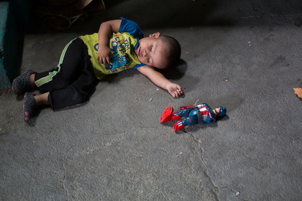 Isidro, the nephew of Paulina Gutierrez Alonzo, plays with a Captain America action figure while she gives an interview at her grandfather's home in Joyabaj, Guatemala, Thursday, July 26, 2018. Gutierrez Alonzo was deported from United States in June and separated from her 7-year-old daughter Antonia Yolanda Gomez Gutierrez, Isidro's cousin, who is currently at an immigration center in Arizona despite the Thursday deadline for reuniting children with their families who were caught entering the country without authorization. (AP Photo/Moises Castillo)
