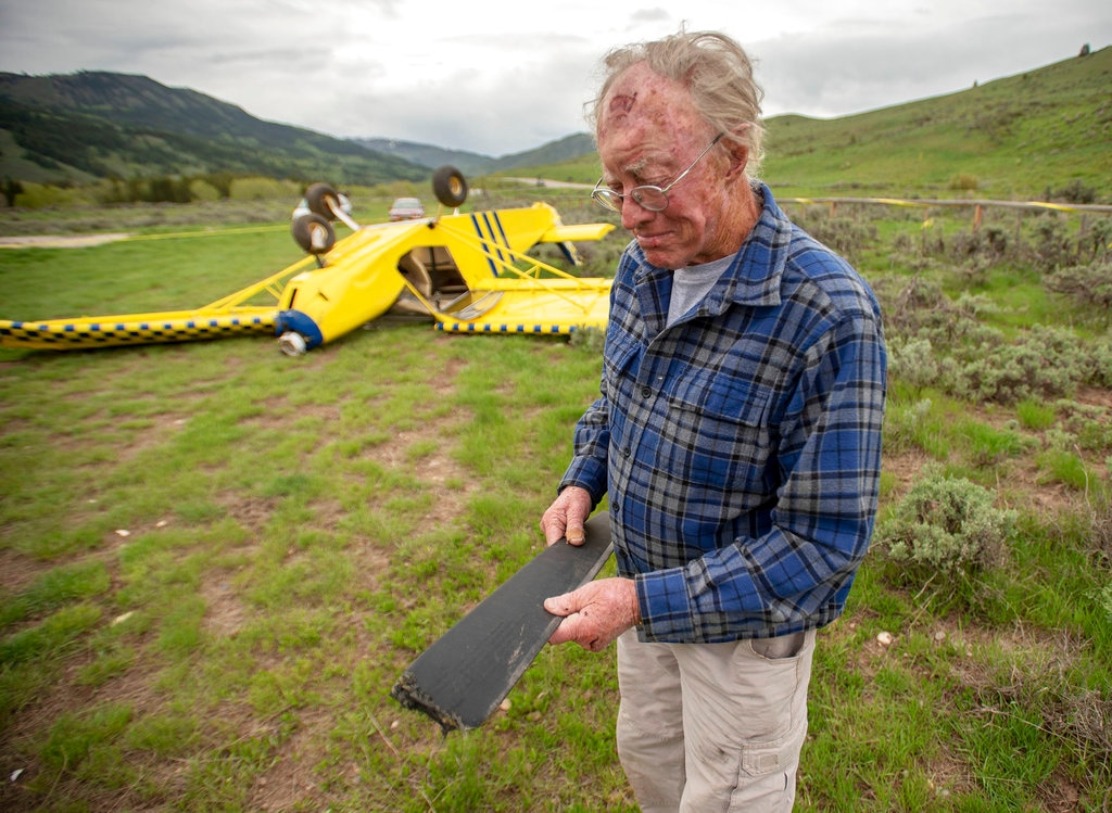 (Bradly J. Boner/Jackson Hole News & Guide via AP) In this May 17, 2018, photo, Charlie Peet, 85, looks at a propeller blade that came off the small airplane he crashed at his Grumpy Moose Ranch south of Jackson, Wyo., the day before. Peet, who also crashed the plane almost five years ago, walked away with only minor injuries. "I have 65 years of flying," he said. "That's enough."