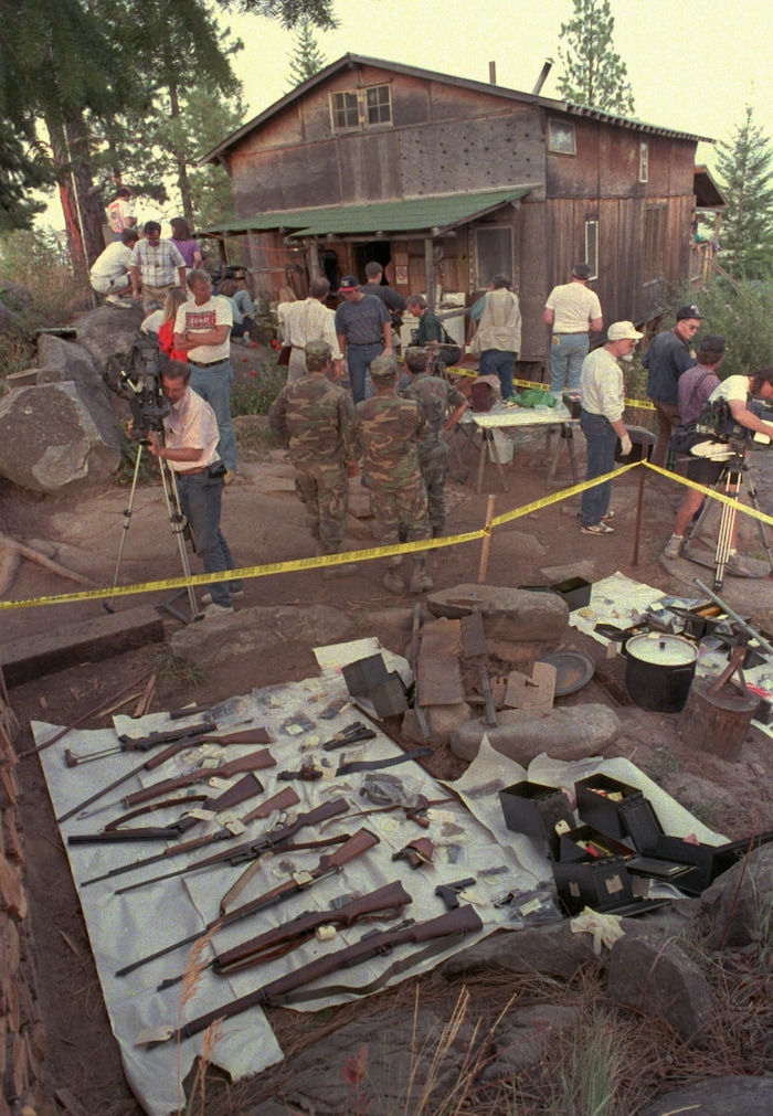 FILE - In this Sept. 1, 1992, file photo, media members and federal agents tour the outside of Randy Weaver's home near Naples, Idaho.It's been a quarter century since a standoff in the remote mountains of northern Idaho left a 14-year-old boy, his mother and a federal agent dead and sparked the expansion of radical right-wing groups across the country that continues to this day. (AP photo/Gary Stewart, File)
