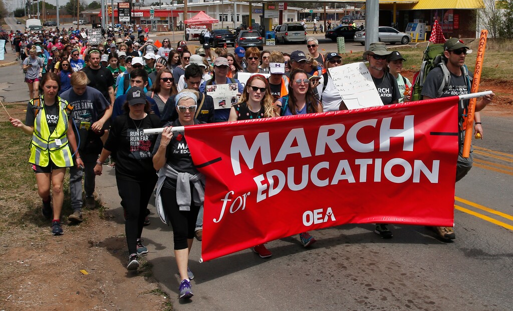 (AP Photo/Sue Ogrocki) Demonstrators walk along N. Kelley Avenue in the final leg of a 110 miles trip from Tulsa to the state Capitol as protests continue over school funding, in Oklahoma City, Tuesday, April 10, 2018. Classes remain canceled in Oklahoma's biggest school districts Tuesday as teachers walk out for a seventh day.