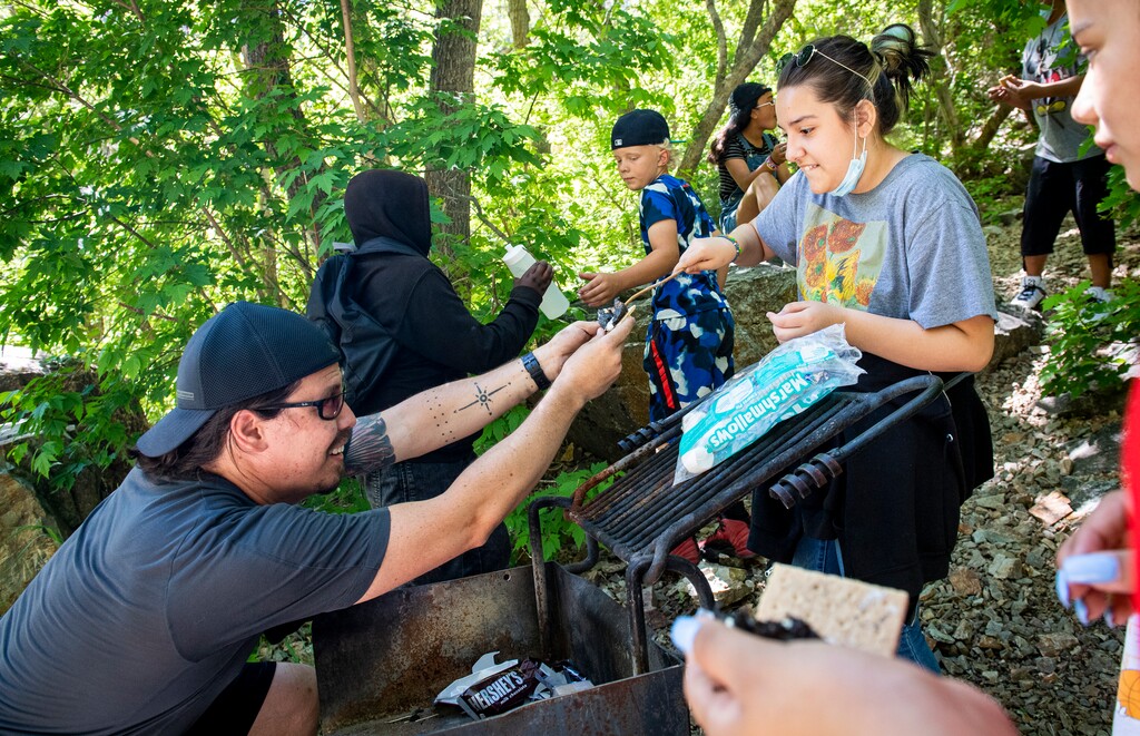 (Isaac Hale | Special to The Tribune) Sixth grade teacher John Arthur helps Marly Mendoza, 12, complete a s’more during an end-of-the-year field trip for Meadowlark Elementary School students in Big Cottonwood Canyon on Friday, June 4, 2021.