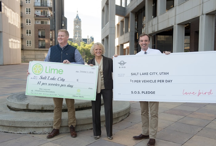 (Rick Egan  |  The Salt Lake Tribune)      Daniel Franklin, operations manager for Lime in Salt Lake City, mayor Jackie Biskupski, and Sam Reed, director of government relations central region for Bird, pose for a photo at a news conference, about the new campaign with e-scooter companies Lime and Bird in an effort to help residents and visitors understand the rules of the sidewalk, Wednesday, Oct. 3, 2018.


