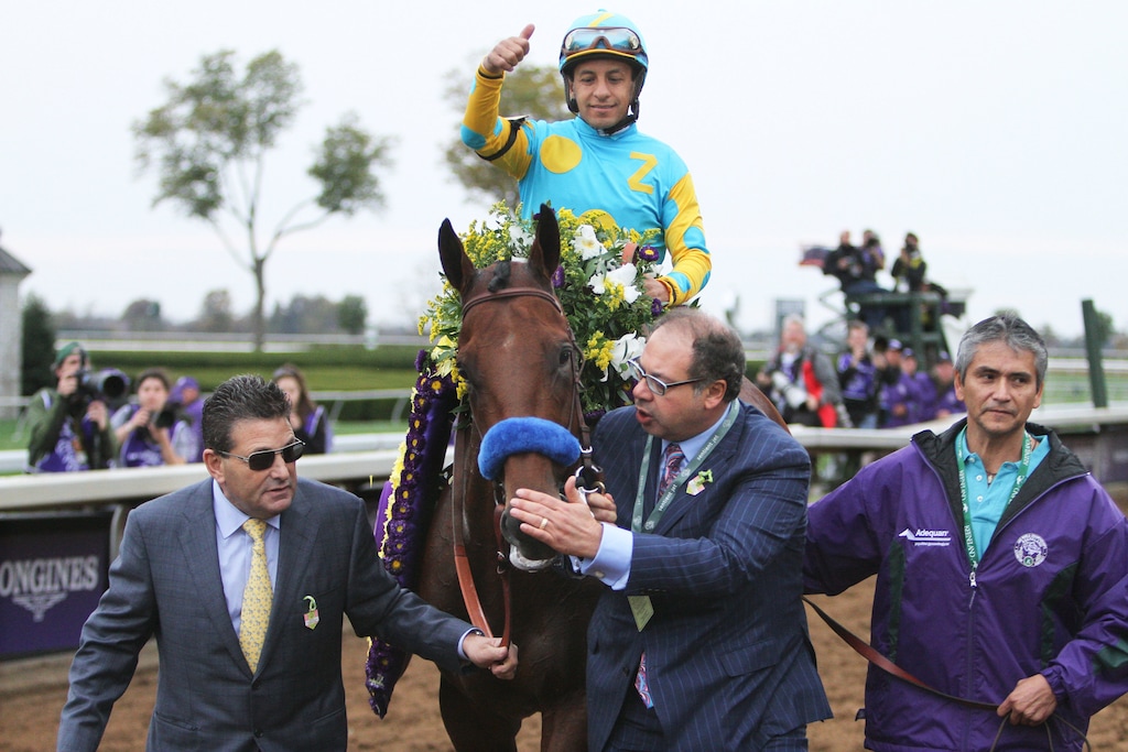 American Pharoah owner Ahmed Zayat pats the horse as jockey Victor Espinoza rides into the winner's circle after winning the Breeders' Cup Classic horse race at Keeneland race track Saturday, Oct. 31, 2015, in Lexington, Ky. (AP Photo/Garry Jones)