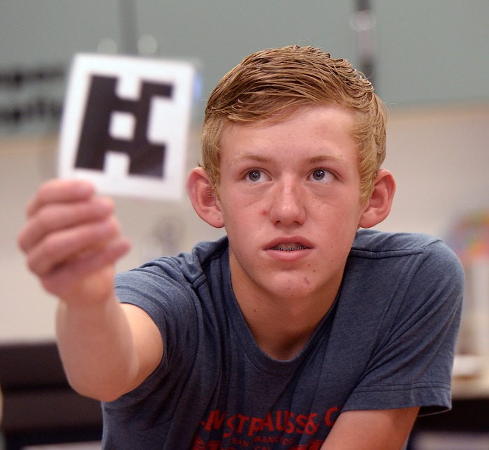 (Al Hartmann | The Salt Lake Tribune) Park Valley School tenth grader Derek Kunzler holds card towards camera that scans and reads his answer as an a., b., c., or d. , via an interactive video conference taught by a history teacher at Bear River High School in Tremonton. The isolated school has to get creative in its teaching methods to serve students.