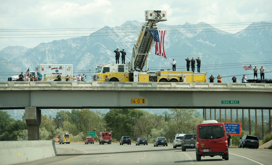 (Rick Egan  |  The Salt Lake Tribune)  Murray Firefighters salute the funeral procession for Utah firefighter Matthew Burchett as it travels down I-215 to the cemetery in Provo, Monday, Aug. 20, 2018.