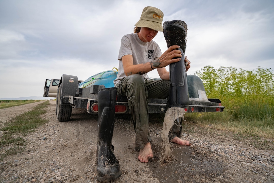 (Francisco Kjolseth | The Salt Lake Tribune) Courtney Check, an ecology student at Utah State University working on her masters degree, empties her muck boot full of water after helping set traps for American white pelicans for a study at the Bear River Migratory Bird Refuge, a 74,000-acre nature reserve in the northern Great Salt Lake on Wednesday, June 23, 2021.