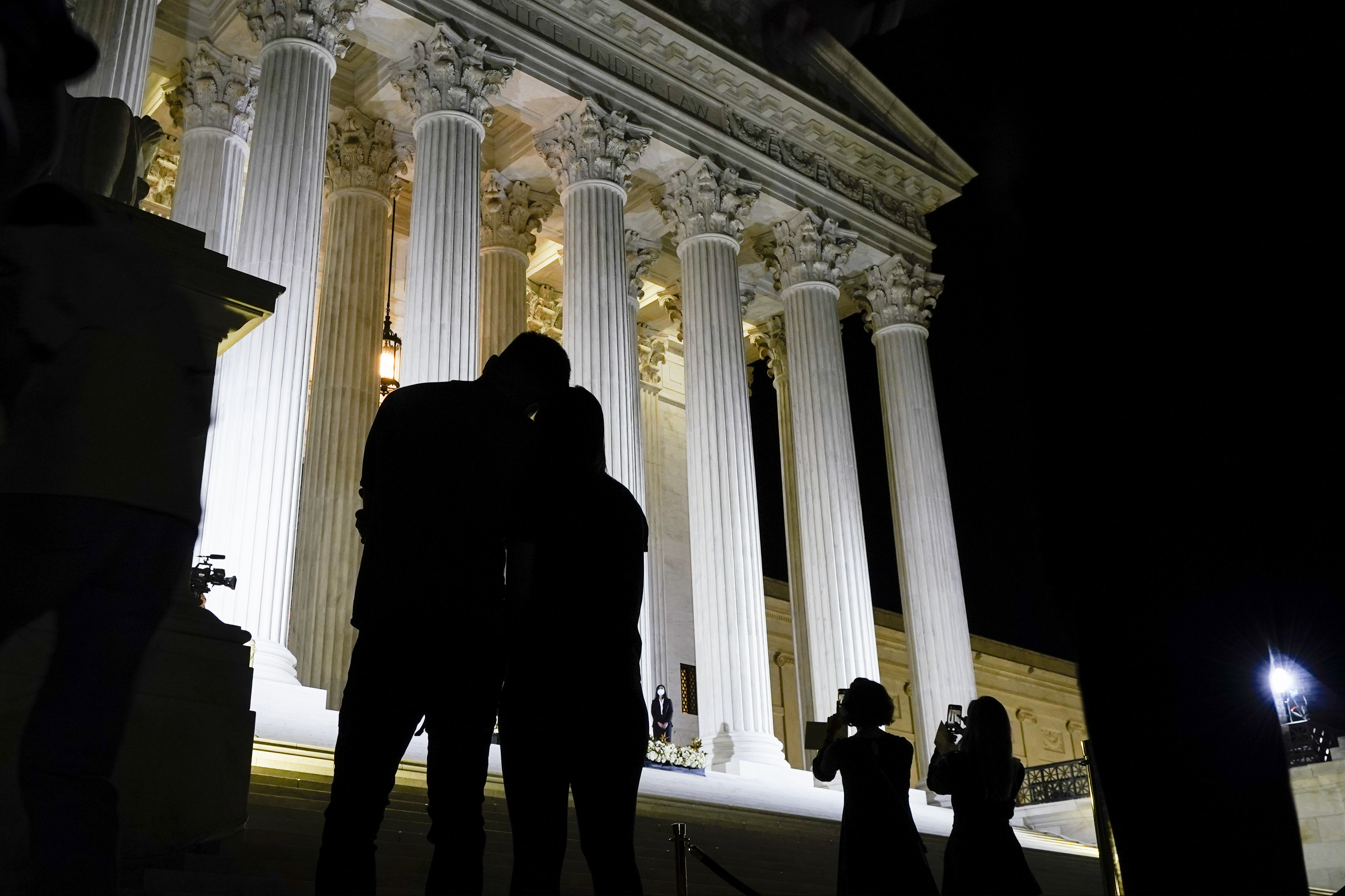 People pay respects as Justice Ruth Bader Ginsburg lies in repose under the Portico at the top of the front steps of the U.S. Supreme Court building on Wednesday, Sept. 23, 2020, in Washington. Ginsburg, 87, died of cancer on Sept. 18. (AP Photo/Alex Brandon)