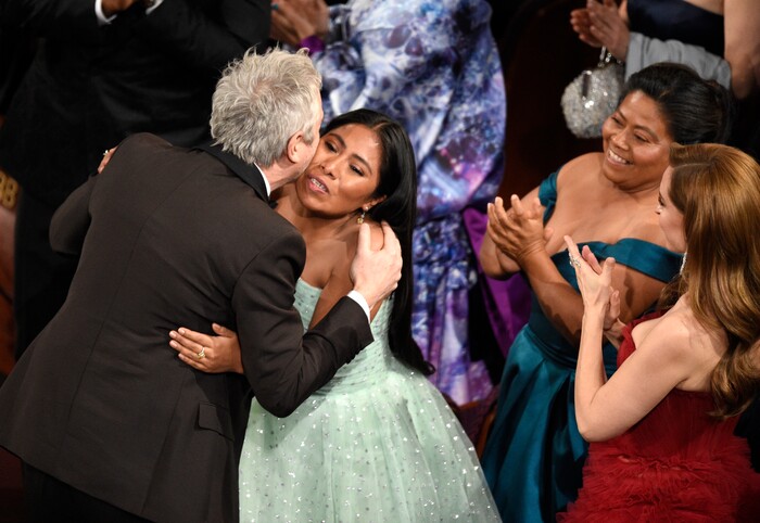Yalitza Aparicio, right, congratulates Alfonso Cuaron in the audience as he is announced the winner of the award for best cinematography for "Roma" at the Oscars on Sunday, Feb. 24, 2019, at the Dolby Theatre in Los Angeles. (Photo by Chris Pizzello/Invision/AP)