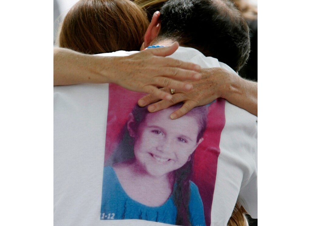 FILE - In this April 25, 2012, file photo, Sergio Celis, wearing a shirt with a picture of his missing 6-year-old daughter, Isabel, gets a hug from a volunteer near their home in Tucson, Ariz. Arizona officials say Christopher Matthew Clements was indicted on Friday, Sept. 14, 2018, in the kidnapping and killing of Isabel Celis in 2012 and 13-year-old Maribel Gonzalez in 2014. (A.E. Araiza/Arizona Daily Star via AP, File)