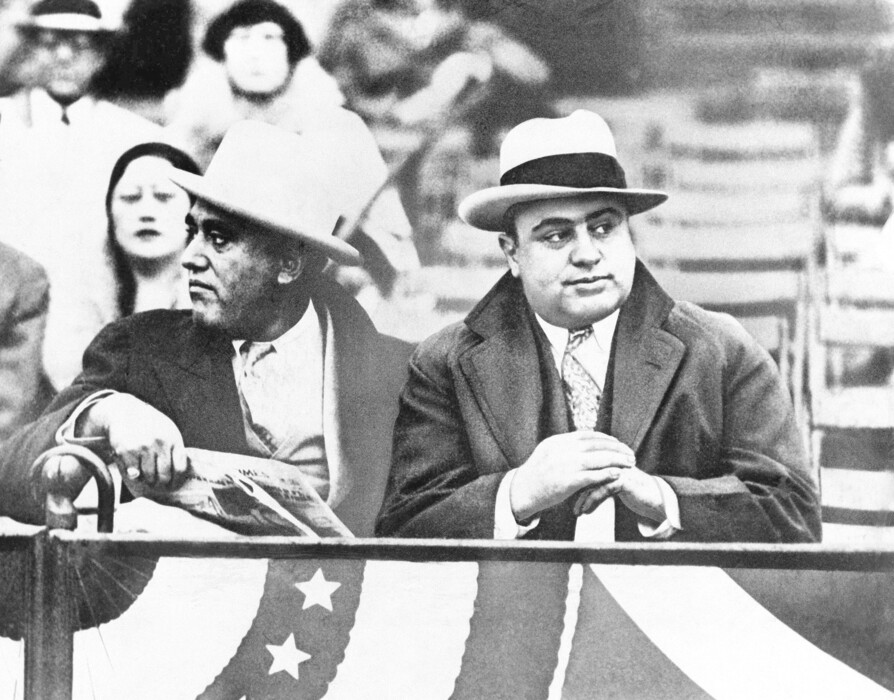 In this Oct. 10, 1931, file photo Al Capone, Chicago gangland, right, attends a game between Notre Dame and Northwestern Grid in Chicago. Former Alderman A.J. Prignano is on the left. (AP Photo, File)