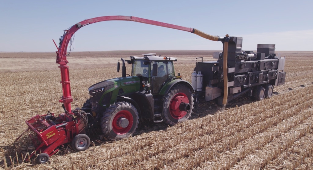 (Applied Carbon) A "pyrolizer," a machine that can apply high heat without oxygen to crop waste and create biochar, is attached to a tractor. Applied Carbon, a Texas startup, has received a $500,000 prize from the University of Utah to develop the technology as a way to store carbon.