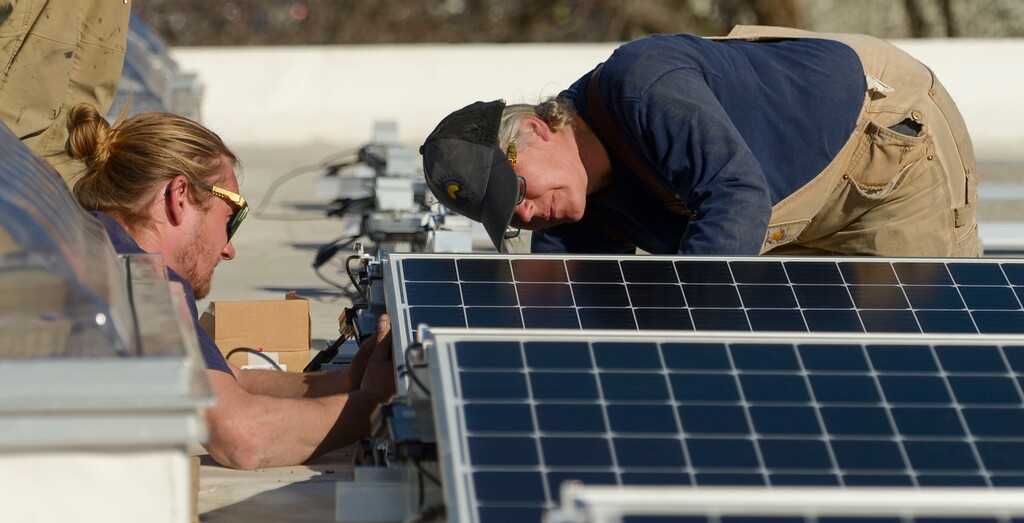 (Leah Hogsten  |  The Salt Lake Tribune) Creative Energies solar installation employees install photovoltaic panels on the roof of the Boys and Girls Club in Salt Lake City, March 5, 2020.