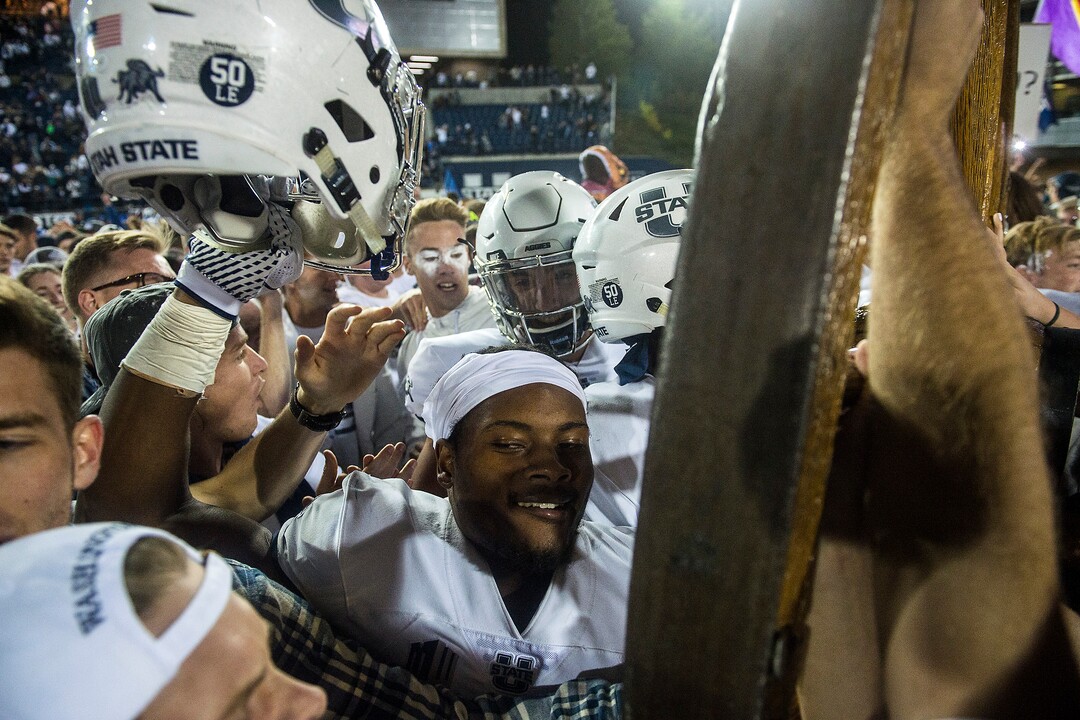 (Chris Detrick  |  The Salt Lake Tribune)  Utah State Aggies  football players and students celebrate with the Old Wagon Wheel after the game at Merlin Olsen Field at Maverik Stadium Friday, September 29, 2017. Utah State Aggies defeated Brigham Young Cougars 40-24.