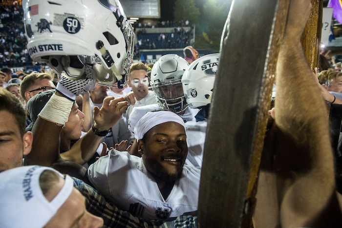 (Chris Detrick  |  The Salt Lake Tribune)  Utah State Aggies  football players and students celebrate with the Old Wagon Wheel after the game at Merlin Olsen Field at Maverik Stadium Friday, September 29, 2017. Utah State Aggies defeated Brigham Young Cougars 40-24.