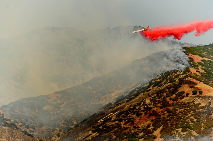 (Trent Nelson | The Salt Lake Tribune)  A plane makes a drop on a fire at the mouth of Weber Canyon, Tuesday September 5, 2017.