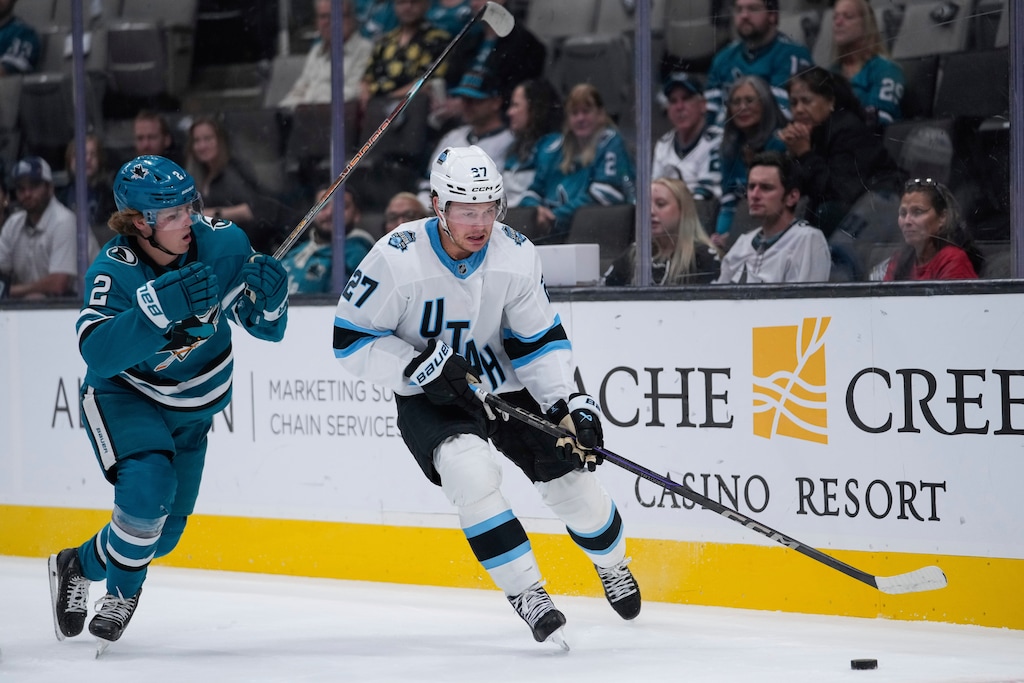 Utah Hockey Club forward Barrett Hayton, right, moves the puck against San Jose Sharks center Will Smith during the first period of a pre-season NHL hockey game, Tuesday, Oct. 1, 2024, in San Jose, Calif. (AP Photo/Godofredo A. Vásquez)