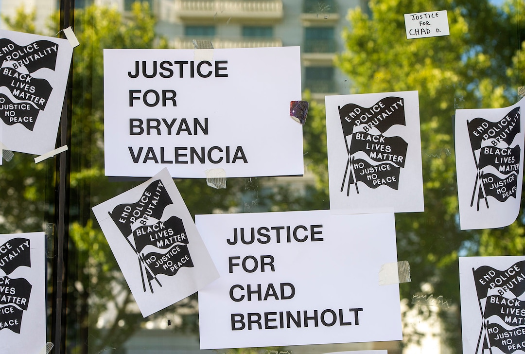 (Rick Egan  |  The Salt Lake Tribune)     Protesters put new signs on the Salt Lake District Attorney's Office, during a protest to draw attention to Chad Breinholt and Bryan Valencia, who, like Bernardo Palacios were killed by the police, Wednesday, July 8, 2020.