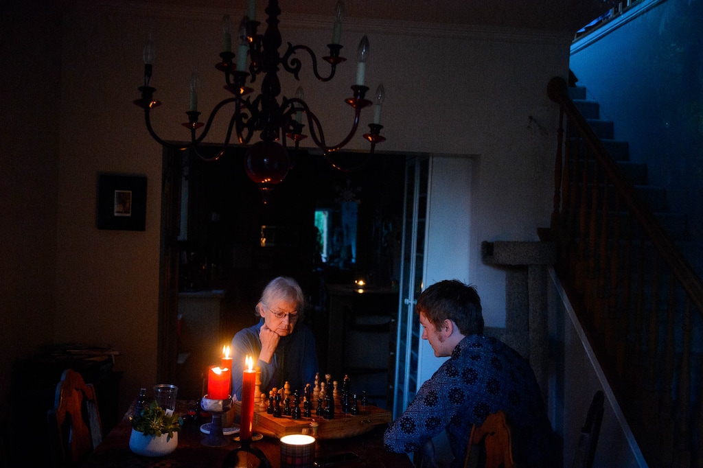 (Trent Nelson  |  The Salt Lake Tribune) Nick Kuzmack and his mother Frances Rowsell play chess by candlelight in their Salt Lake City home on Friday, Sept. 11, 2020. They have been without power since Tuesday's high winds.