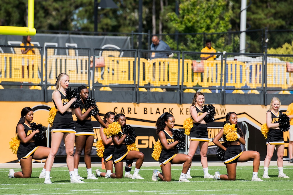 In this Saturday, Sept. 30, 2017 photo, five Kennesaw State University cheerleaders take a knee during the national anthem prior to a college football game against North Greenville, in Kennesaw, Ga. (Cory Hancock/Atlanta Journal-Constitution via AP)