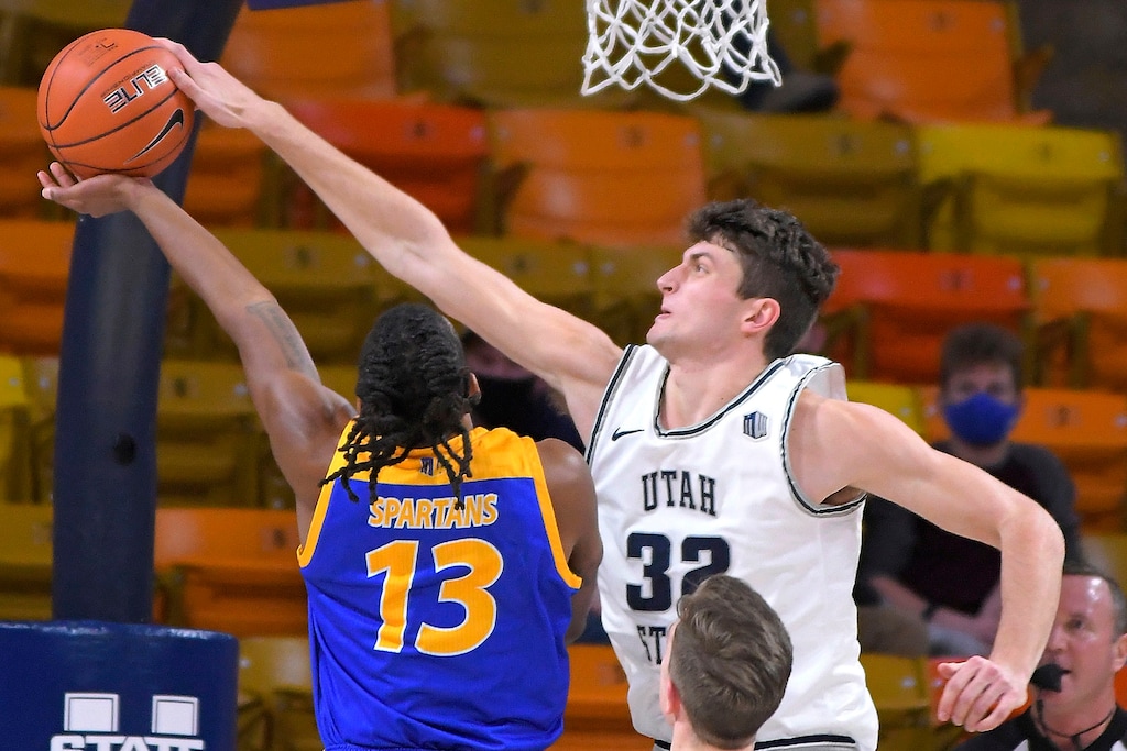 San Jose State guard Seneca Knight (13) has his shot blocked by Utah State center Trevin Dorius (32) as forward Justin Bean (34) helps defends during the first half of an NCAA college basketball game Wednesday, Dec. 23, 2020, in Logan, Utah. (Eli Lucero/The Herald Journal via AP, Pool)