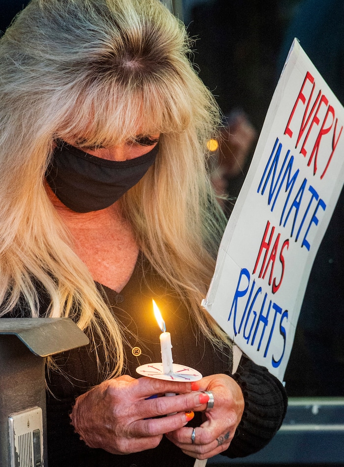(Rick Egan  |  The Salt Lake Tribune)   A woman named Brenda holds a candle during a prayer for inmates, after a COVID-19 outbreak has spread at the Draper prison, during a rally at the Department of Corrections, on Tuesday, Oct. 13, 2020.