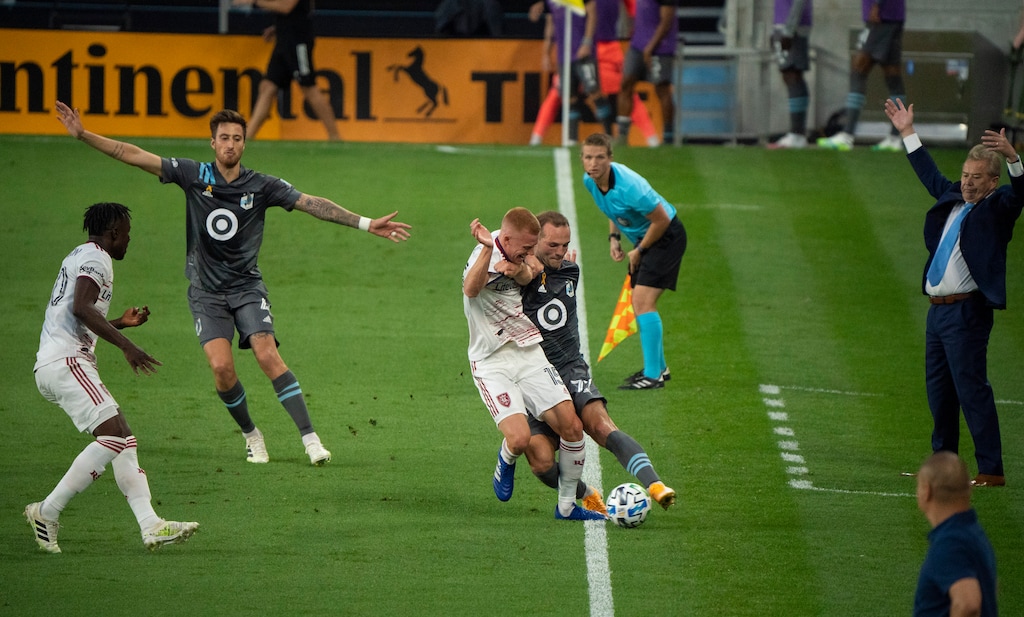 Minnesota United defender Chase Gasper (77) tries to keep the ball inbounds despite the efforts of Real Salt Lake defender Justen Glad (15) during the first half of an MLS soccer game, Sunday, Sept, 6, 2020 in St. Paul, Minn. (Jeff Wheeler/Star Tribune via AP)