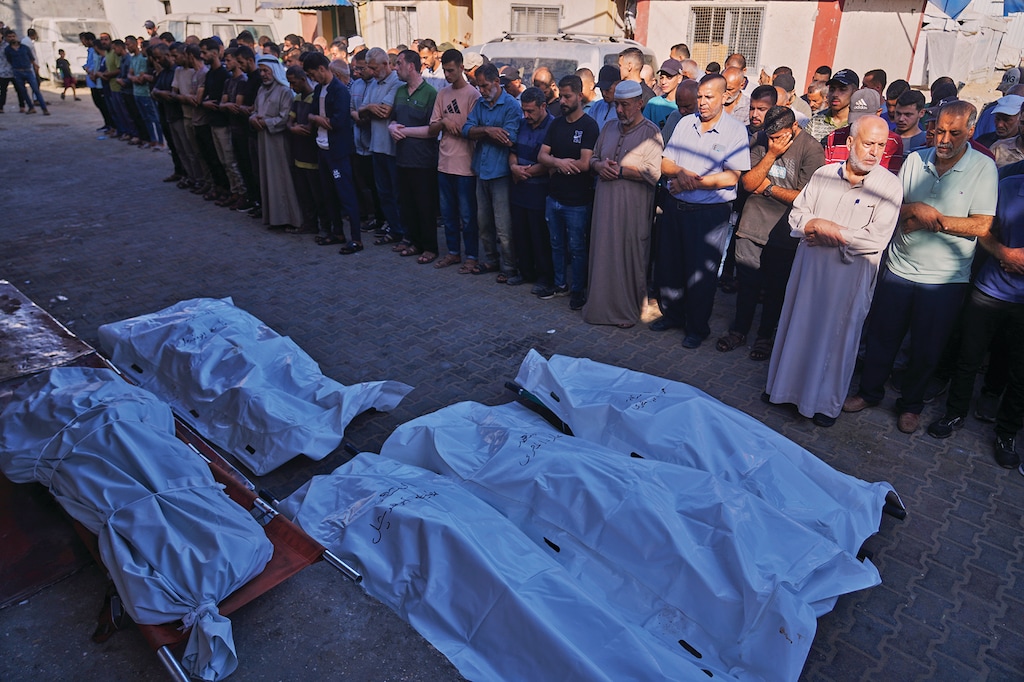 Palestinians pray over the bodies of people killed in an Israeli military strike as they gather outside Al-Aqsa Hospital in Deir al-Balah, in the central Gaza Strip, Monday, Sept. 1, 2025. (AP Photo/Abdel Kareem Hana)
