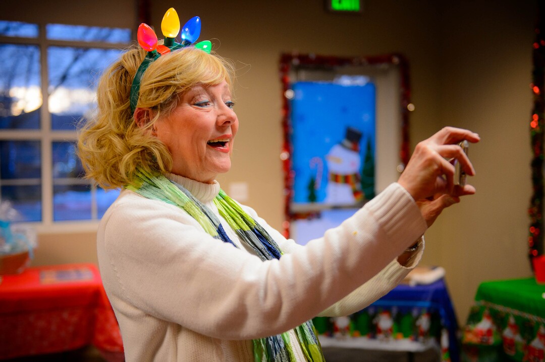 (Trent Nelson | The Salt Lake Tribune) Lynda Smart Brown, founder of KidsEat!, takes a photograph at a fundraiser and coat collecting event in Murray on Wednesday, Dec. 11, 2019.